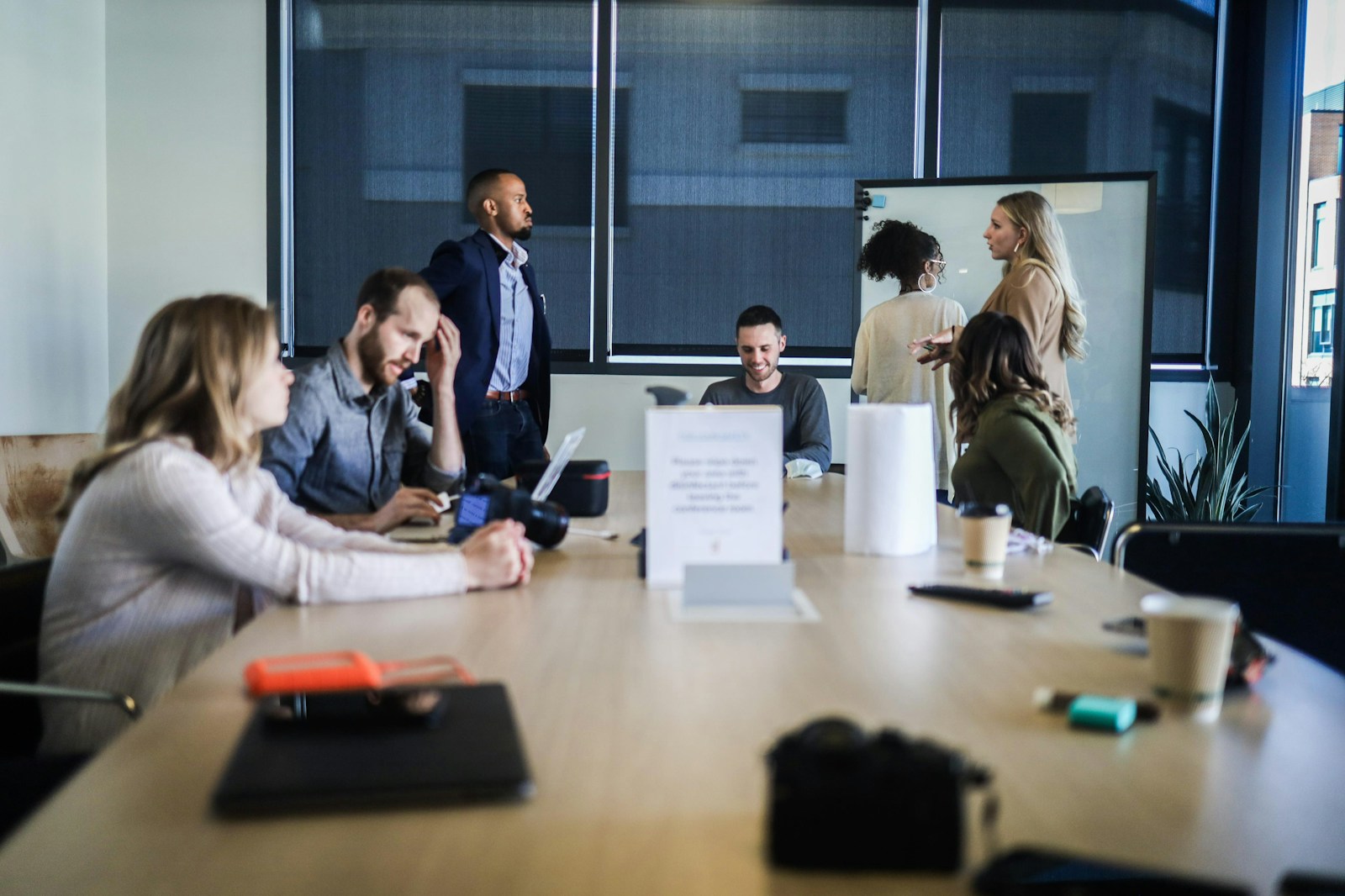 Team collaborating around a conference table with laptops