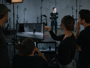 CGI music video previsualization studio with an artist reviewing a virtual stage plan