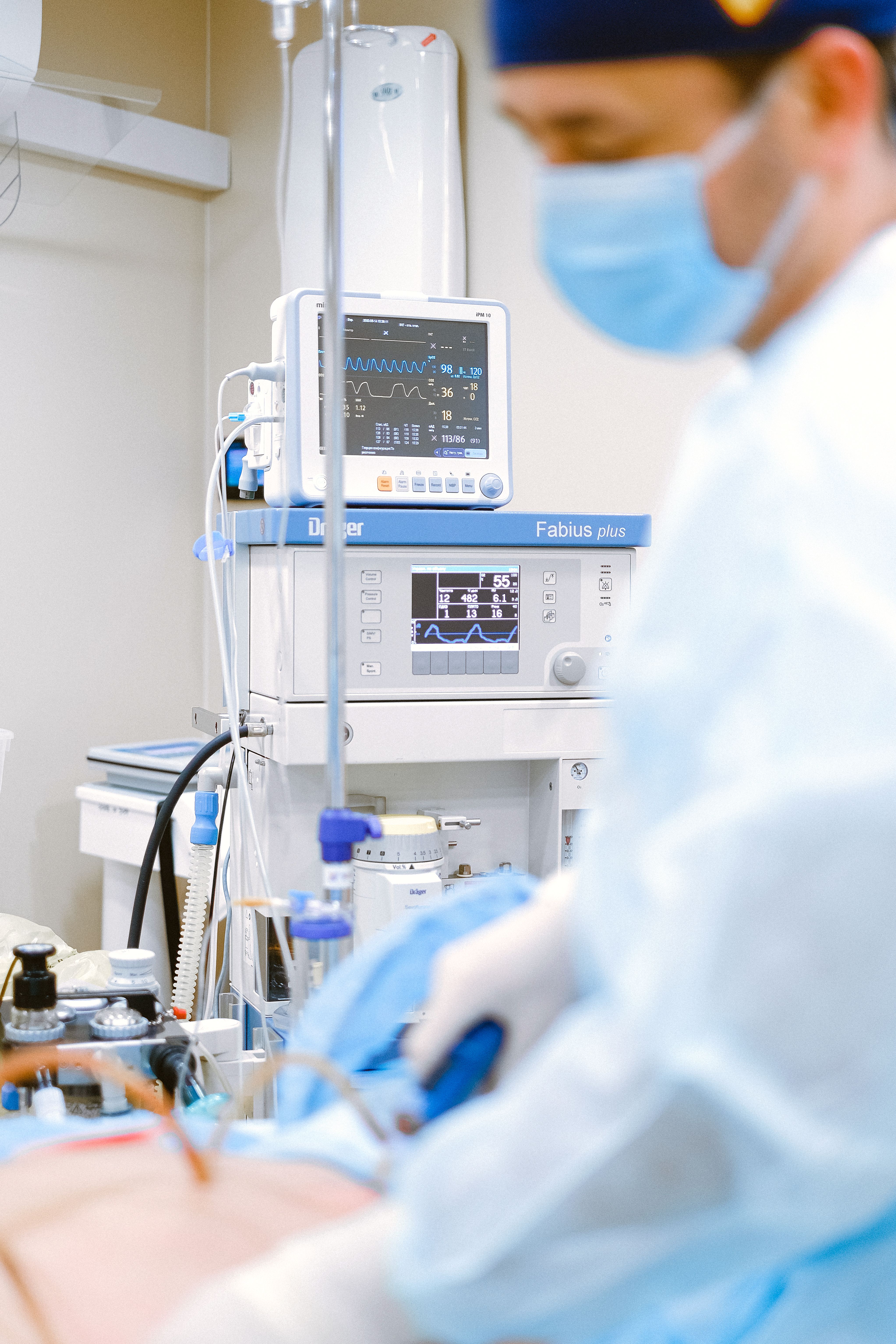 Clinician working with a patient and medical monitor in a hospital setting