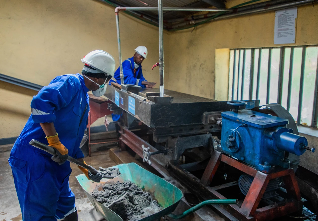 Industrial workers comparing maintenance approaches on production machinery