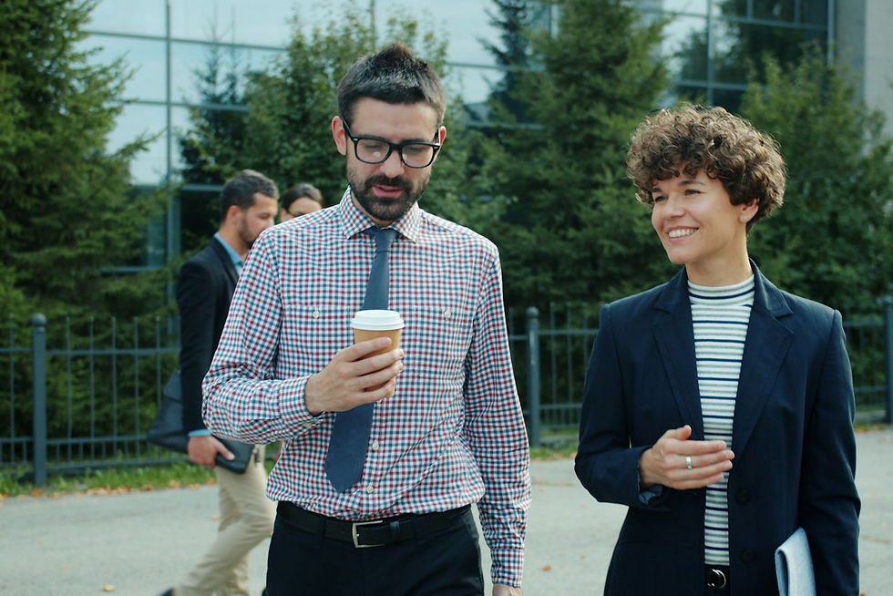 Two colleagues walking and talking outside an office building