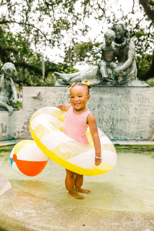 girl playing in Audubon Park's children's fountain for a photography session