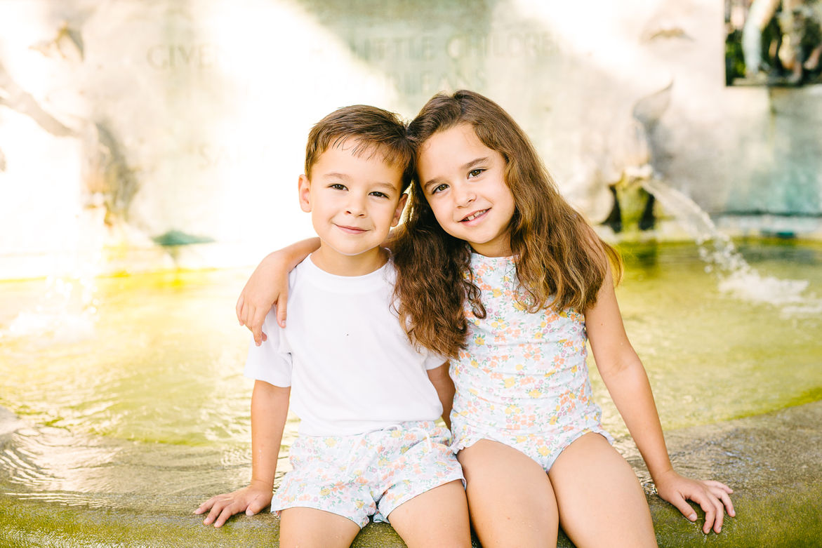 boy and girl posing in Audubon Park's children's fountain for a photography session