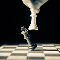 Close up of white king taking down black