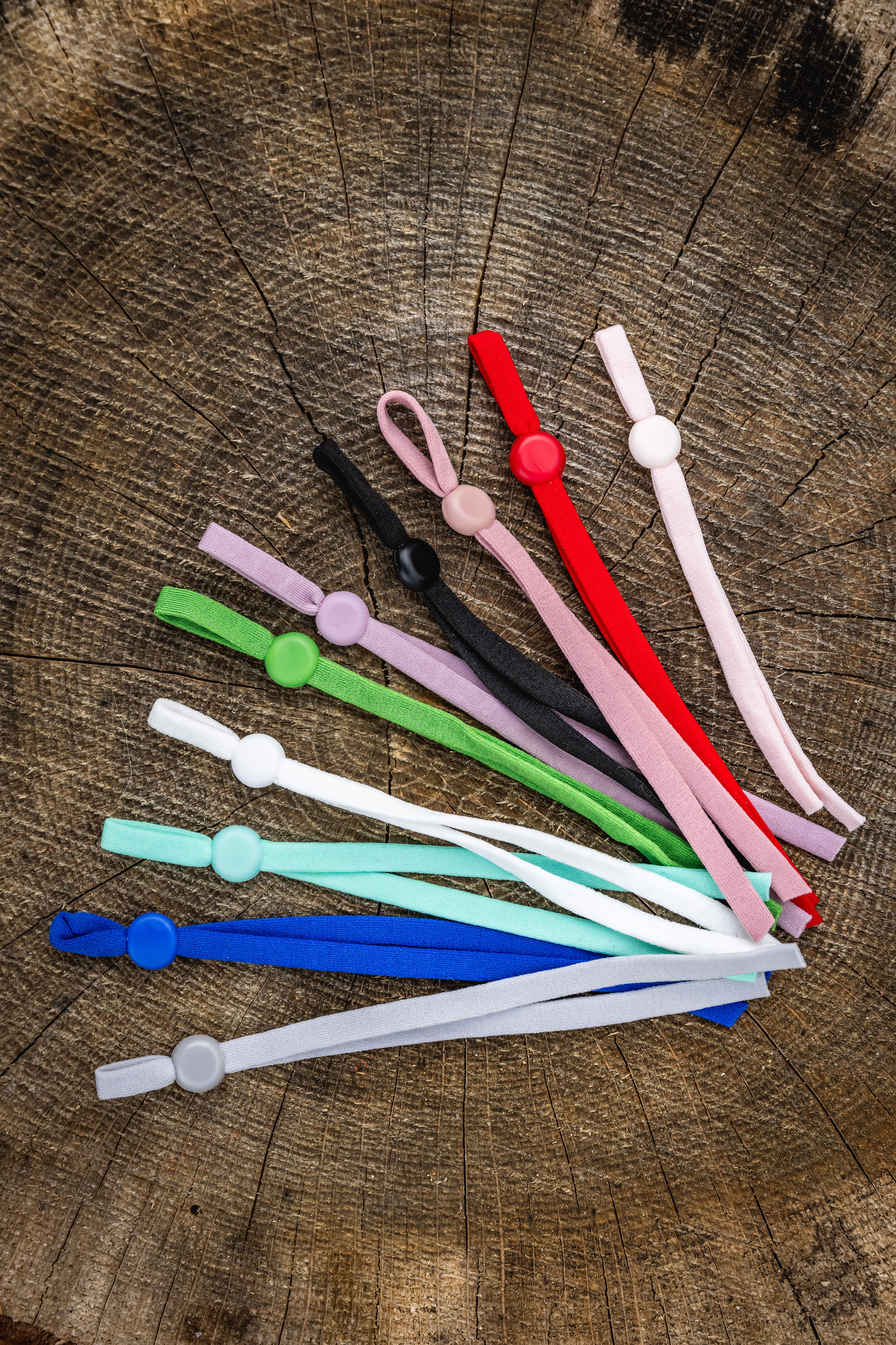 Newborn puppy collars in range of bright colours on log