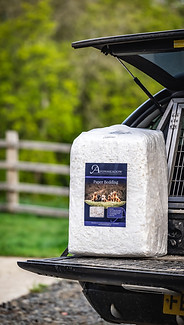 A bale of paper bedding on the back of pick up truck