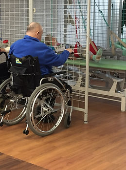 Pacjent na wózku ćwiczy w kabinie UGUL