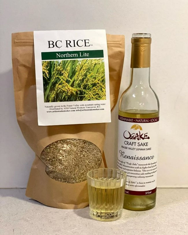 A bag of rice grown by Artisan Sake Maker in BC's Fraser Valley, beside a bottle and a glass of craft sake.