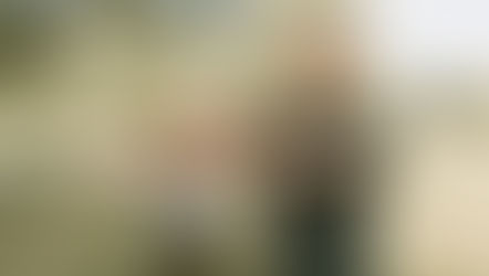 Two people practicing tai chi in a serene park. They stand with arms extended, eyes closed, conveying a calm and focused mood.