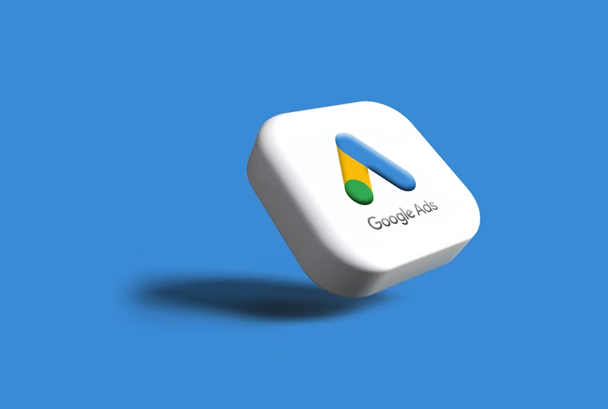 Floating 3D Google Ads logo on a blue background. White block with colorful arrow and shadow, text reads "Google Ads."