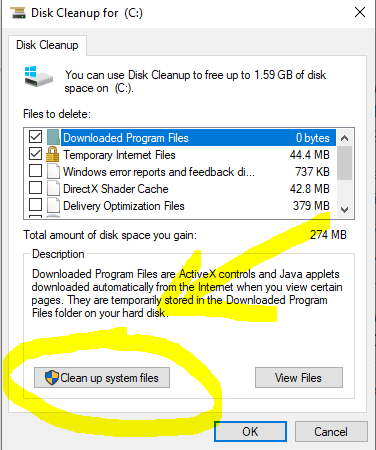 Screenshot of the Disk Cleanup utility window, with the 'Clean up system files' button highlighted. The user is selecting Drive C from the drop-down menu and clicking the 'OK' button to initiate the cleaning process.