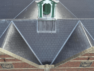 Close-up of Shireland Collegiate Academy's pitched roof and bell tower, finished with BMI Redland Cambrian reconstituted slate tiles.