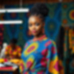 A beautiful model wearinga bubu made from vibrant african prints on a colorful background