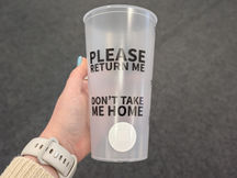 A reusable cup that says "Please Return Me" and "Don't Take Me Home" with a circular RFID tag attached to the bottom.