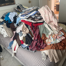 Large pile of clothing on a bed