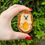 Thumbnail: An adorable acrylic hedgehog brooch being held in the makers hand in daylight
