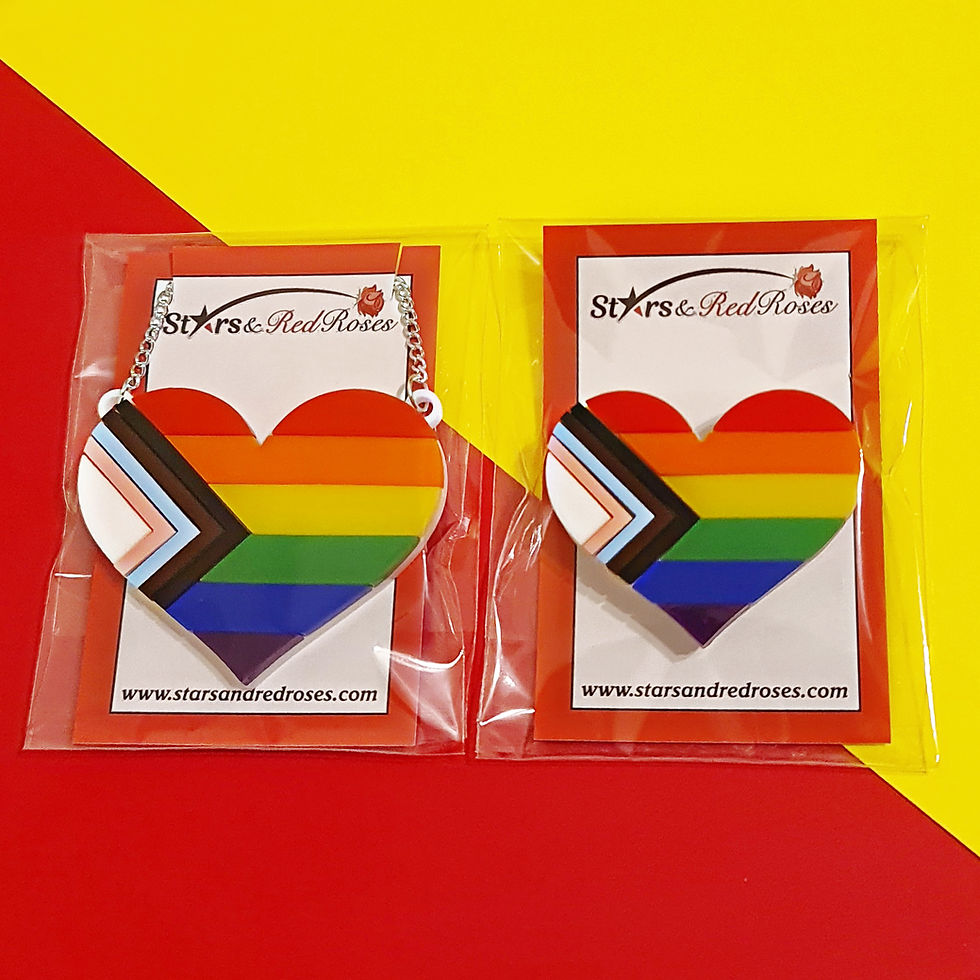 Miniatura: Both the progress pride heart brooch and necklace displayed inside cellophane packaging
