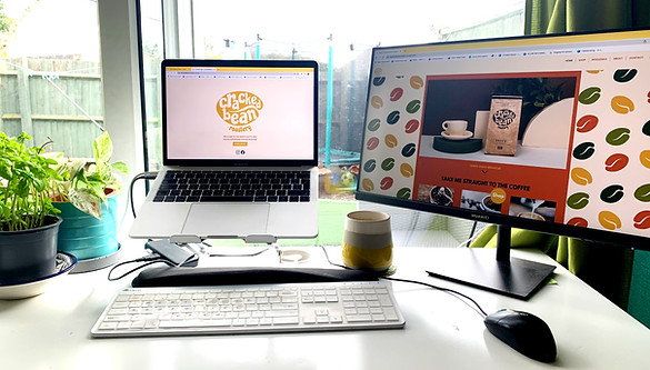 An image of two screens on a desk showing the cracked bean roastery website