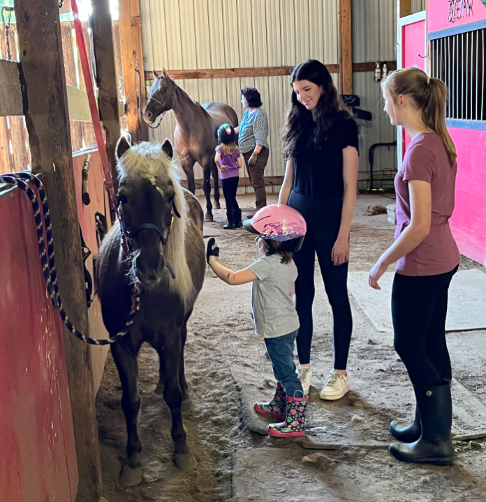 Young Hearts riders grooming their horses before a ride.
