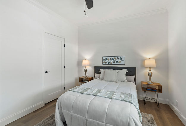 Bright bedroom with bed, lamps, and closet