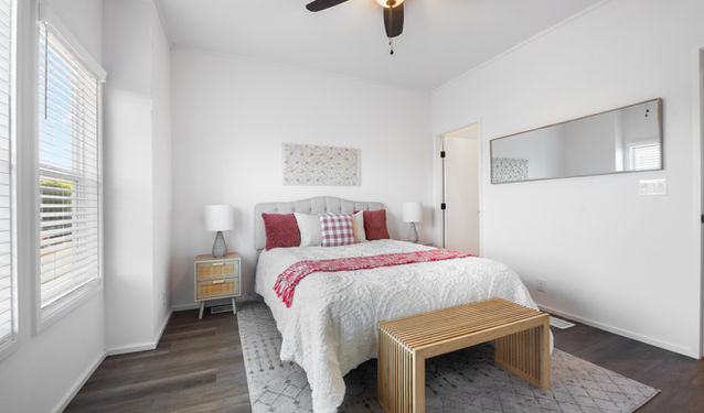 Bright bedroom with king bed, wood floors, and window