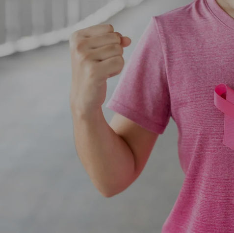 Person with pink ribbon, raised fist