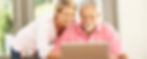 older man and younger women searching on a laptop