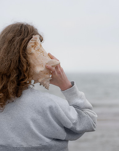 a woman holding a seashell up to her face_edited.jpg