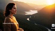 A woman standing on a mountain viewpoint at sunset, softly smiling while looking at a scenic river winding through the valley .