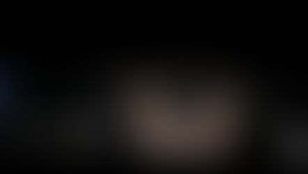 A close-up shot of a person’s eyes in dim light, showing intense blue eyes and a focused, expressive gaze, symbolizing deep emotions and the power of eye contact.