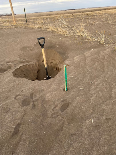 Wind erosion soil pit showing sand accumulation in roadside ditch South Dakota drought conditions