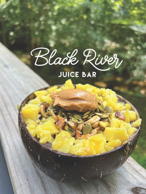 Smoothie bowl with Black River JUICE BAR text, pineapple, seeds, peanut butter.