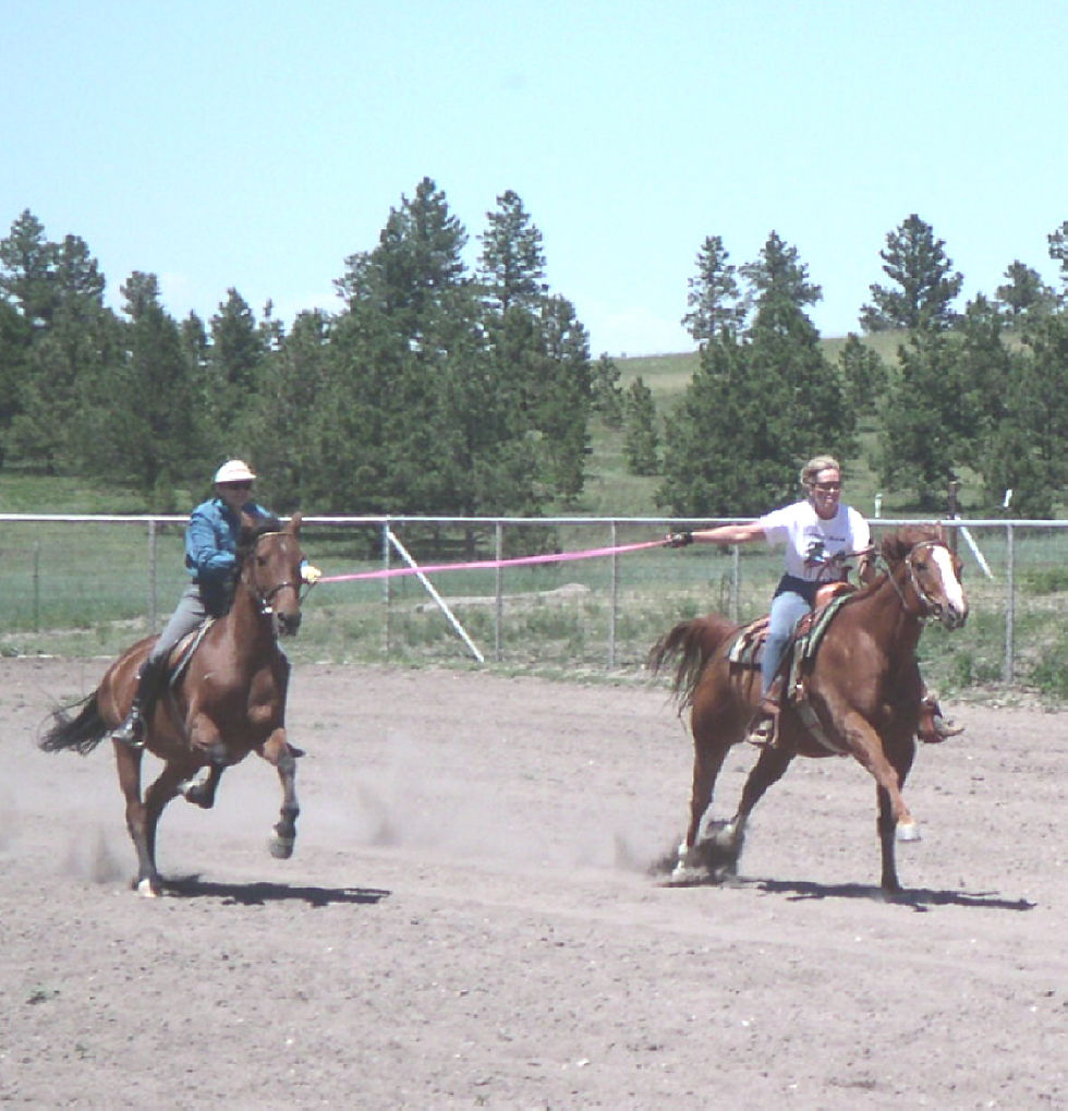 Deb Deaton riding her rescued horse Scottie during a playful race in Colorado, sharing a moment of joy and healing.