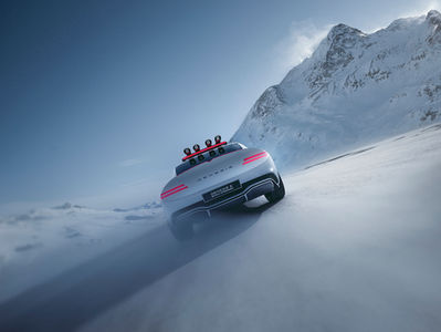 Luxury car navigating snowy roads in the Engadin region, surrounded by majestic mountains