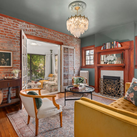 Vintage style living room with wood fireplace and brick wall in historic Denver short term rental home