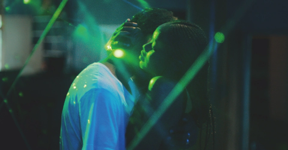 Ada and Souleiman from Atlantics are dancing intimately in a empty nightclub, green strobe lights surround them