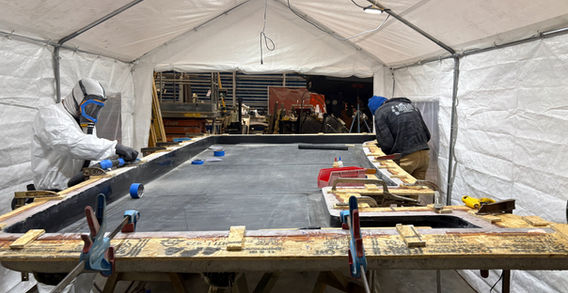 ESI technicians building a large fiberglass panel layup under a temporary work tent, Anacortes shipyard