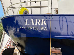 Transom of the custom steel sailing vessel Lark, Anacortes WA, after fresh navy topside paint at ESI