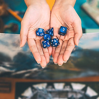 Role playing tabletop game and board games hobby concept. Hand holding blue dice on blur b