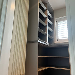 a floor level photo of grey open shelving and a shoe rack on an oak floor 