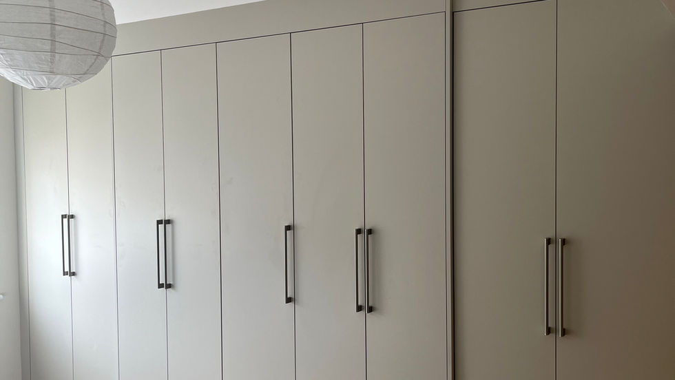 A bank of wardrobe doors in a room with a white ceiling and beige carpet