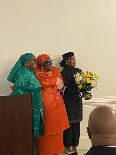 Flanked by her daughter, Sister Saadiqa (l), Sister Sophia Muhammad (r.) Student Captain Nancy receives her flowers and award with gratitude.