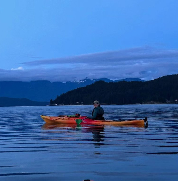 A photo of the author in a kayak at dusk.