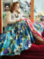 Cotton gathered skirt made from deadstock fabric from the 70s. White lace shirt, blue and pink skirt, red couch.