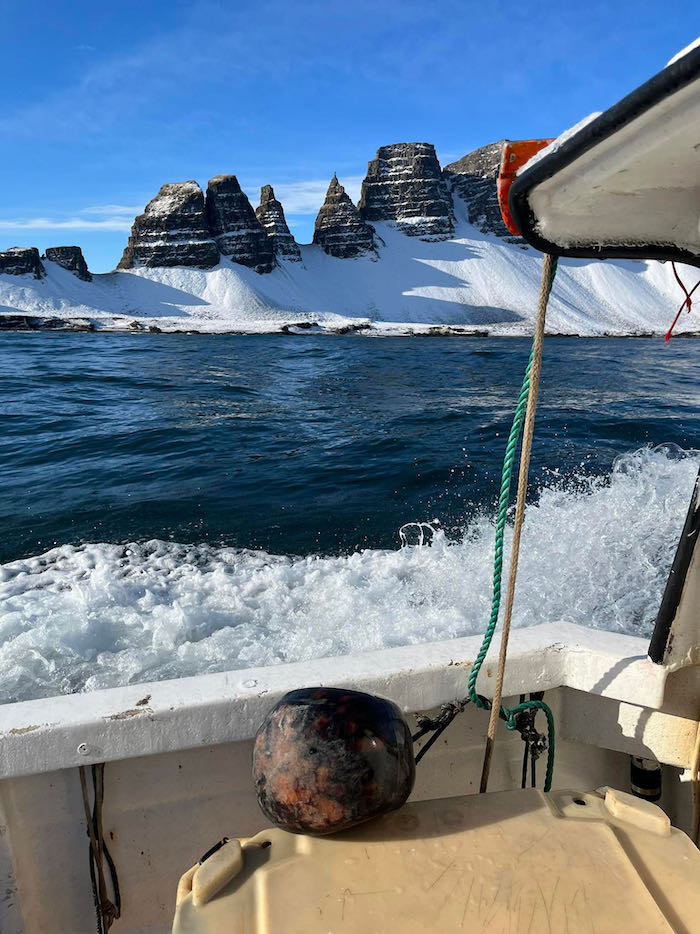 Guðni snaps a photo from his uncle's boat of the Drangaskörð rock formation jutting out from the Skarðafjall mountain.