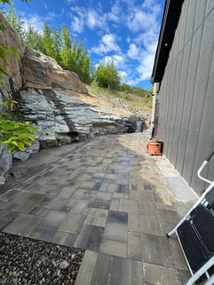 paver stone lay interlock path beside house with rock hardscaping beside