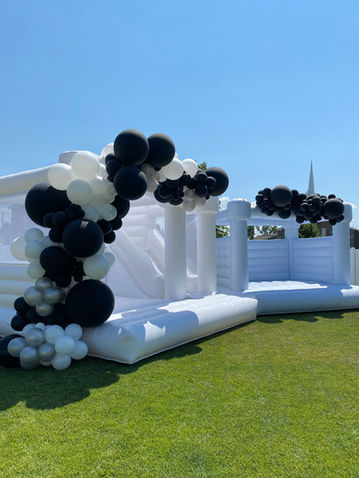 Two bounce castles , a 15x15 and a 13x13 with black and white balloon accents. 