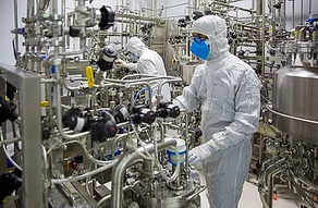 Scientists working in a germ free environment manufacturing vaccines.