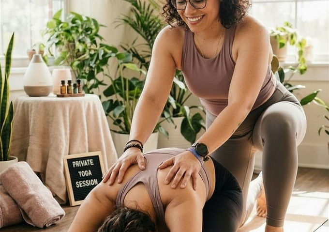 Image of Jo offering hands on assistance for student in childs pose
