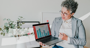 Mulher olhando para um notebook com vários gráficos na tela